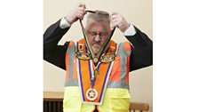 An Orangeman gets ready. Sashes were originally of the ceremonial shoulder-to-hip variety as worn by the British military