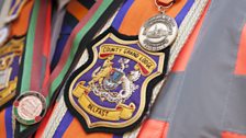 Orangemen wear sashes embroidered with their lodge name or number