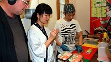 John Toal learning how to make sushi with Erica Shu and her husband