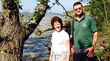 Jamie Marsh, Reserves Officer with the Isle of Wight Wildlife Trust, shows Helen the impact of the sea at Bouldnor.