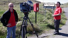 Cameraman Richard Cook filming on Eriskay with local postman Iain Rhuaraid MacInnes