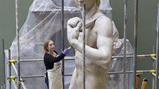 Conservator Johanna Puisto dusts the cast of Michelangelo's David post conservation, Nov 2014 in the Weston Cast Court