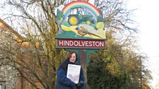 A very cheerful-looking village sign!