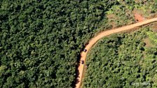 Cars travel on a road just outside of Freetown, Sierra Leone