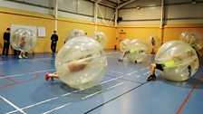 Sgoilearan Àrd-Sgoil MhicNeacail a’ cluich ball-coise zorb