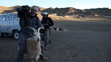 Producer/director Alexis Girardet pretends to ride a friendly goat with soundman Mark Roberts in the background