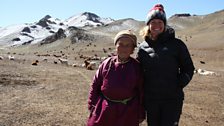 Kate and 78 year old matriarch, Chimed, stand in the snow capped mountains of the Gobi Desert