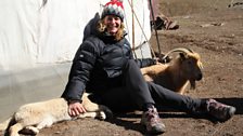 Kate sits with George the puppy and Zegle the goat outside the nomads Ger