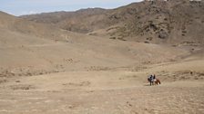 Kate and nomadic herder Ordnor ride horses across the Gobi Desert