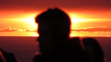 Presenter Anthony Isaacs in silhouette in Happisburgh