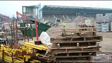 The view of the Main Stand is obscured by building supplies.