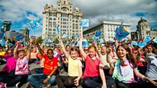 Liverpool children wave flags for ý Music Day