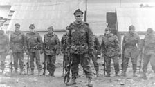 Lt Co Alfredo Astiz & his men stand to salute during their occupation of Leith, South Georgia.  April 1982.jpg