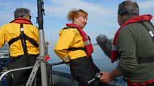 Skipper Tim Barton (left), Barbara Cheney (centre) onboard their dolphin research boat with presenter Euan McIlwraith