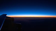 The sun begins to rise from the window of SOFIA, NASA’s flying infrared telescope