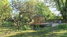 Pond and summer house through the trees