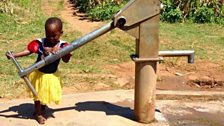 A child plays with a water pump