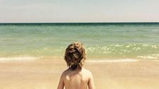 A child looks out to sea