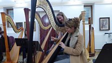 Producer Georgia Mann-Smith sits at the harp.