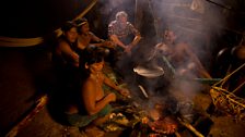 Cooking up dinner -  Penti and his wife Daboto prepare wild peccary that they've hunted to feed the tribe