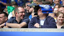 Leicester City fans share a laugh in the stands