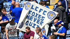 Leicester City fans in the stands hold up a banner