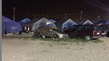 Tent city includes government-supplied tents & plastic covered shacks built by the migrants themselves.