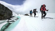 The team walk past melting ice