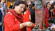 A Hindu women lights ceremonial oil lamps around the Indrayani temple during Dashain festival