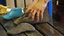 Shaping the damp boots around a shoe tree.