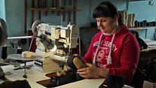 Olga Kuznetsova sews the labels and piping onto the slipper boots