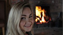 Eileen McKee beside the fire at Tossies Cottage