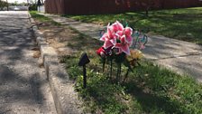 Lilies mark the spot where the body of Nisa Mickens was found