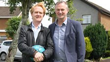 Owen and Michael in Ballymena, with his old home in the background