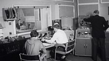 The radio control room, with the studio visible through the glass