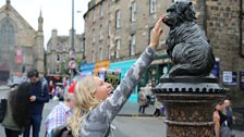 Presenter Nikki Bedi touches the nose of Greyfriar's Bobby