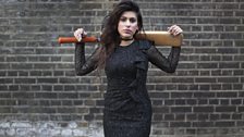 Black dress, blue nails, cricket bat