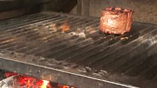 Fillet steak cooking over coals