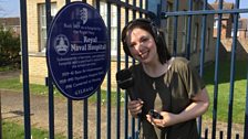 Anna poses with the plaque at the entrance