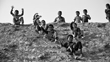 Children slide down a hill in Kutupalong refugee camp