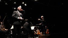 Ken Bruce on stage with Richard Balcombe and the 鶹ƵAV Concert Orchestra