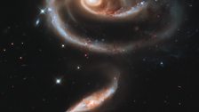 Arp 273. This galaxy has a disk distorted into a rose-like shape by the gravitational tidal pull of the companion galaxy below