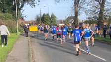 The team give the runners a wave as they set off down the road....