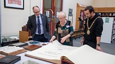 The Lord Mayor of Belfast is shown some books from the Central Library archive during Love Your Library Day 2024