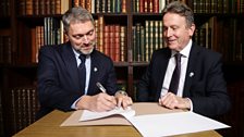 Adam Smyth signing the renewal of the ѿý NI and Libraries NI partnership