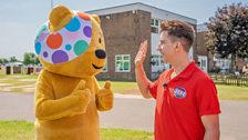 Russell Kane high-fiving Pudsey Bear