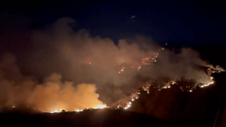 Glowing fires and orange smoke from hilltops