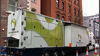A large outside broadcast truck parked in a street.