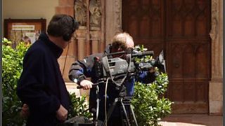 A camera man and sound man recording a broadcast in a church.