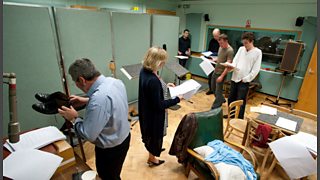 A variety of sound effects of feet walking are made during a drama recording in the radio studio